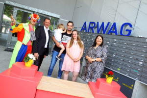 (C) PID/Votava: Der Clown sorgte beim Willkommensfest für Stimmung bei Simmerings Bezirksvorsteher Thomas Steinhart, der frisch eingezogenen Familie –  Papa Rene, Raphael und Mama Lisa – und Vizebürgermeisterin und Wohnbaustadträtin Kathrin Gaál.