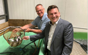 (C) Berger: Bezirksvorsteher Wilfried Zankl machte sich vor Ort selbst ein Bild von der Frische der Fische von Züchter Marc Mößmer (l.).