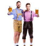 Men in traditional bavarian clothes holding mugs of beer