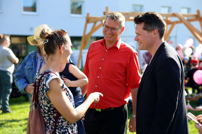 Klimastadtrat Czernohorszky (r.) mit Bezirsvorsteher Papai und einer Bewohnerin beim Familienfest im Gaswerkpark.