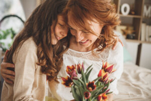 Kind schenkt Mutter Blumen zum Muttertag