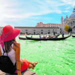 Female tourist looking the Basilica di Santa Maria della Salute and Canale Grande in Venice, Italy