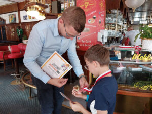 Medaillenübergabe an ein an der Rätselrallye teilnehmendes Kind.