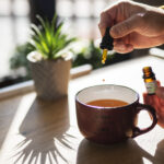 Man using CBD oil in his tea.
