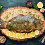 Baked Fish Carp with Vegetables. Top view. Free space for your text. Rustic style.