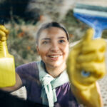 Young woman cleaning car window