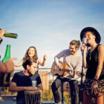 Group of friends are celebrating with a concert on the roof terrace