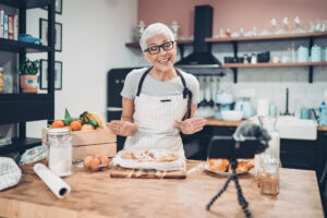 Frau vor Handy-Kamera beim Kochen