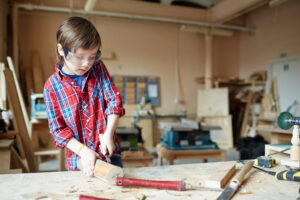 Kleiner Junge areitet mit Holz