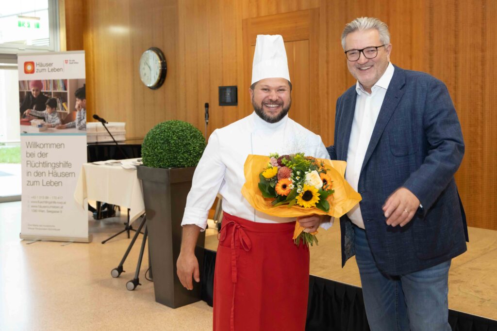 Stadtrat Peter Hacker und Herr Ashraf. Nach einem erfolgreich absolvierten Arbeitsintegrationsprojekt ist der ehemalige Bewohner der Flüchtlingshilfe nun bereits seit vier Jahren im Haus Döbling als Mitarbeiter in der Küche tätig.