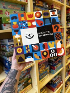 Wilmot’s Warehouse (ab 8, CMYK) Ein kooperatives Kommunikationsspiel: Gemeinsam wird ein Warenlager sortiert – doch um sich zu merken, wo was liegt, braucht es gute Absprachen und kreative Eselsbrücken. Teamarbeit ist hier der Schlüssel zum Erfolg. © Peter Wieser