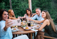 Umfrage: Braucht gute Laune wirklich Alkohol? Friends Celebrating Lunch Outdoors in Scenic Nature And Taking Selfies